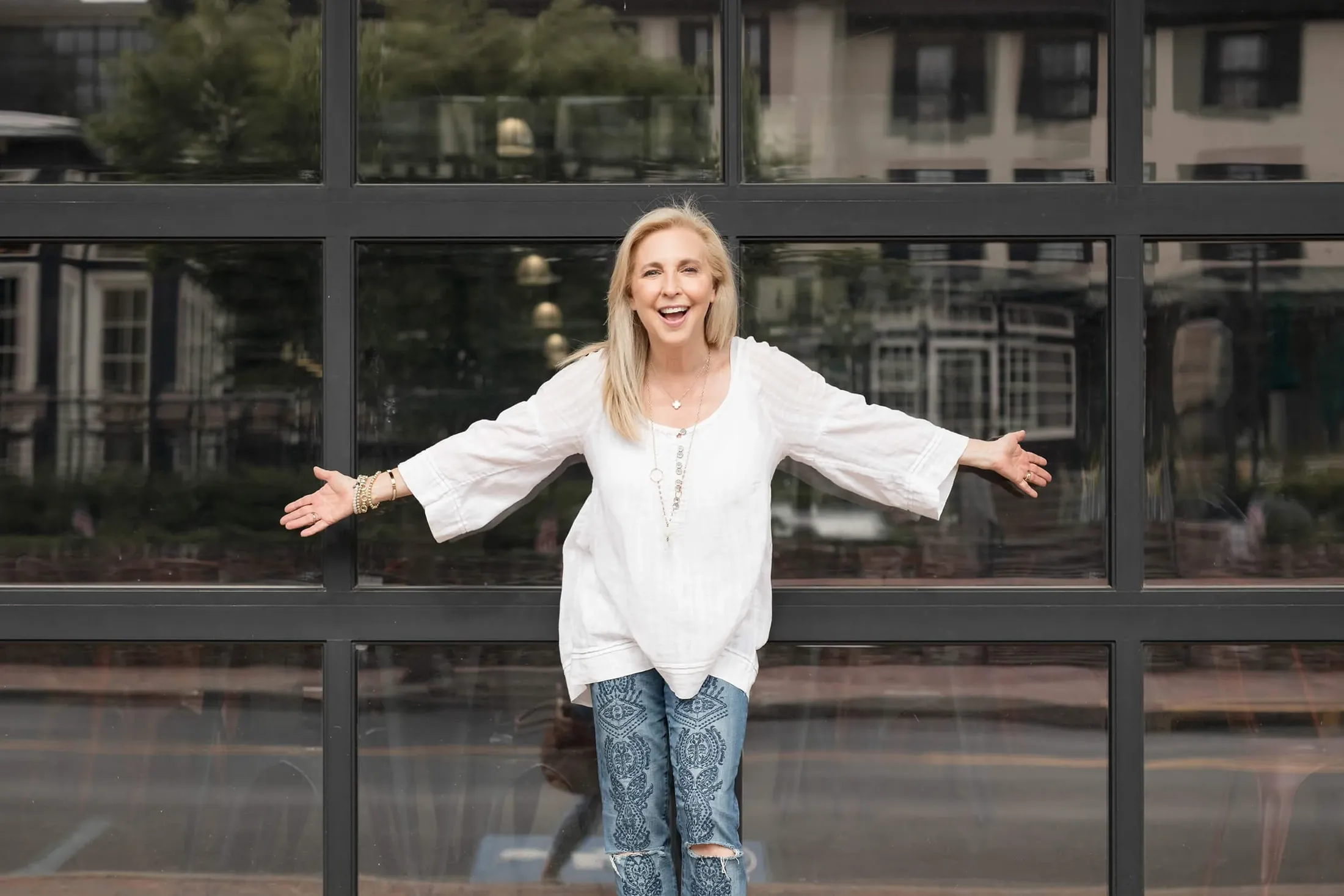 Lauren Yellin Weinberg with her arms open wide, smiling